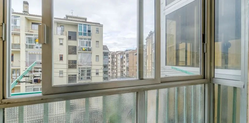 Un balcón acristalado ofrece vistas a edificios de apartamentos vecinos.