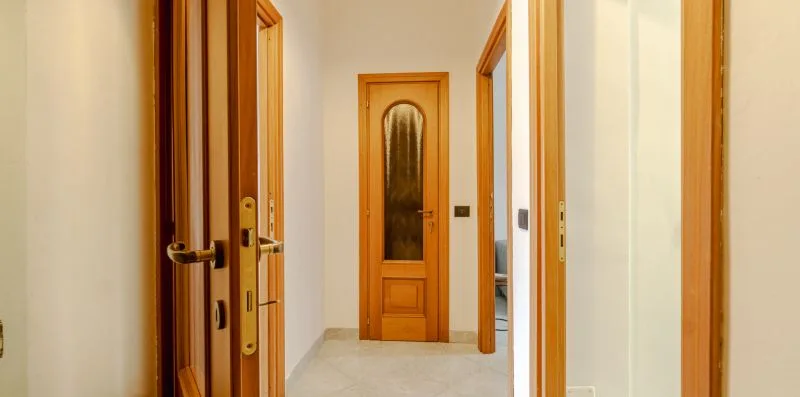 Un pasillo con puertas de madera y un suelo claro.