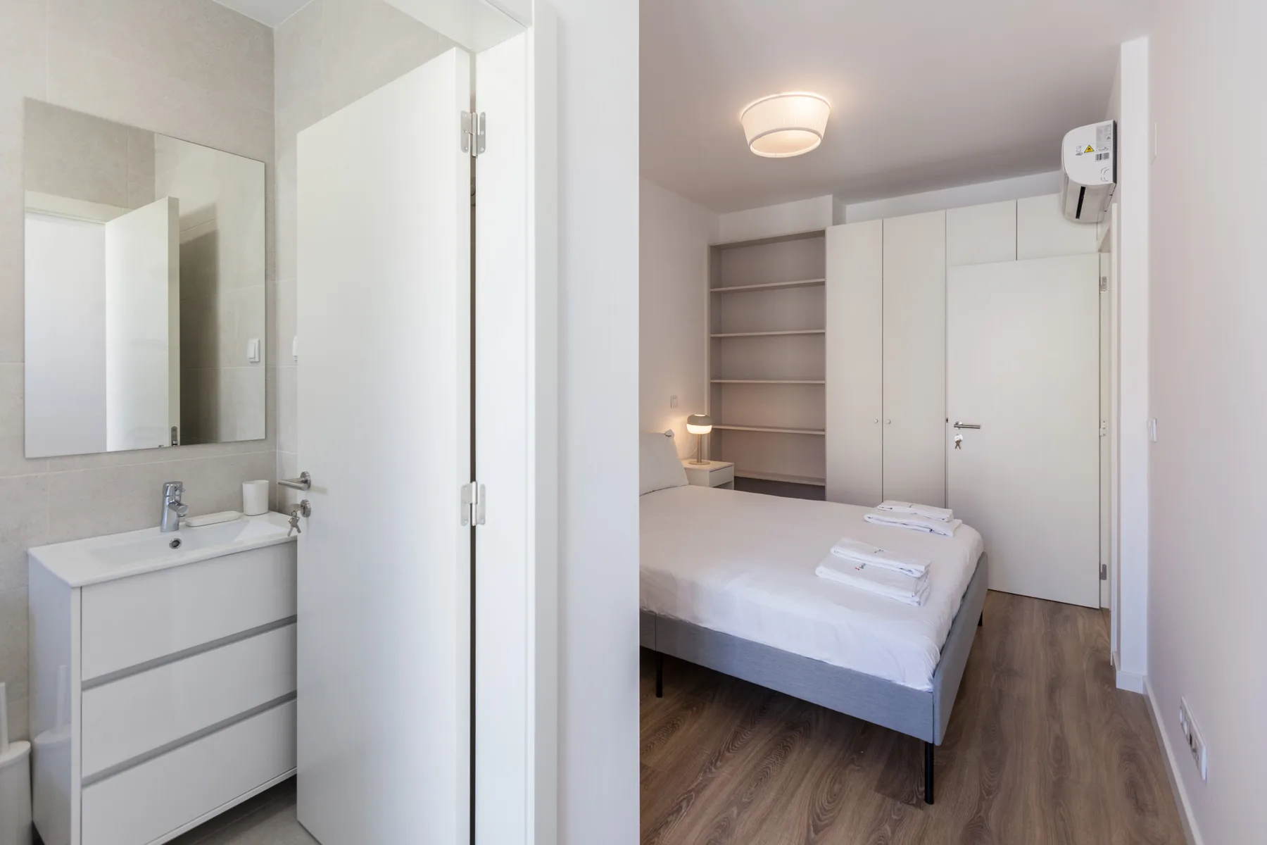 Un dormitorio con una cama, estantes empotrados y un armario blanco.