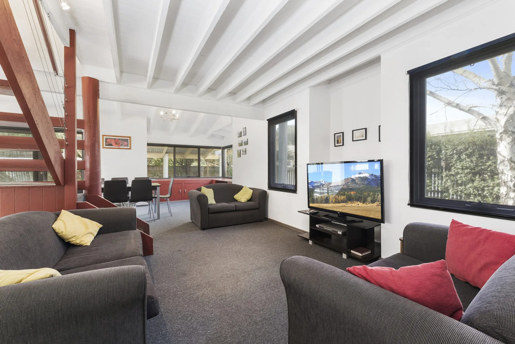 A living room with seating, a television, and a dining area.