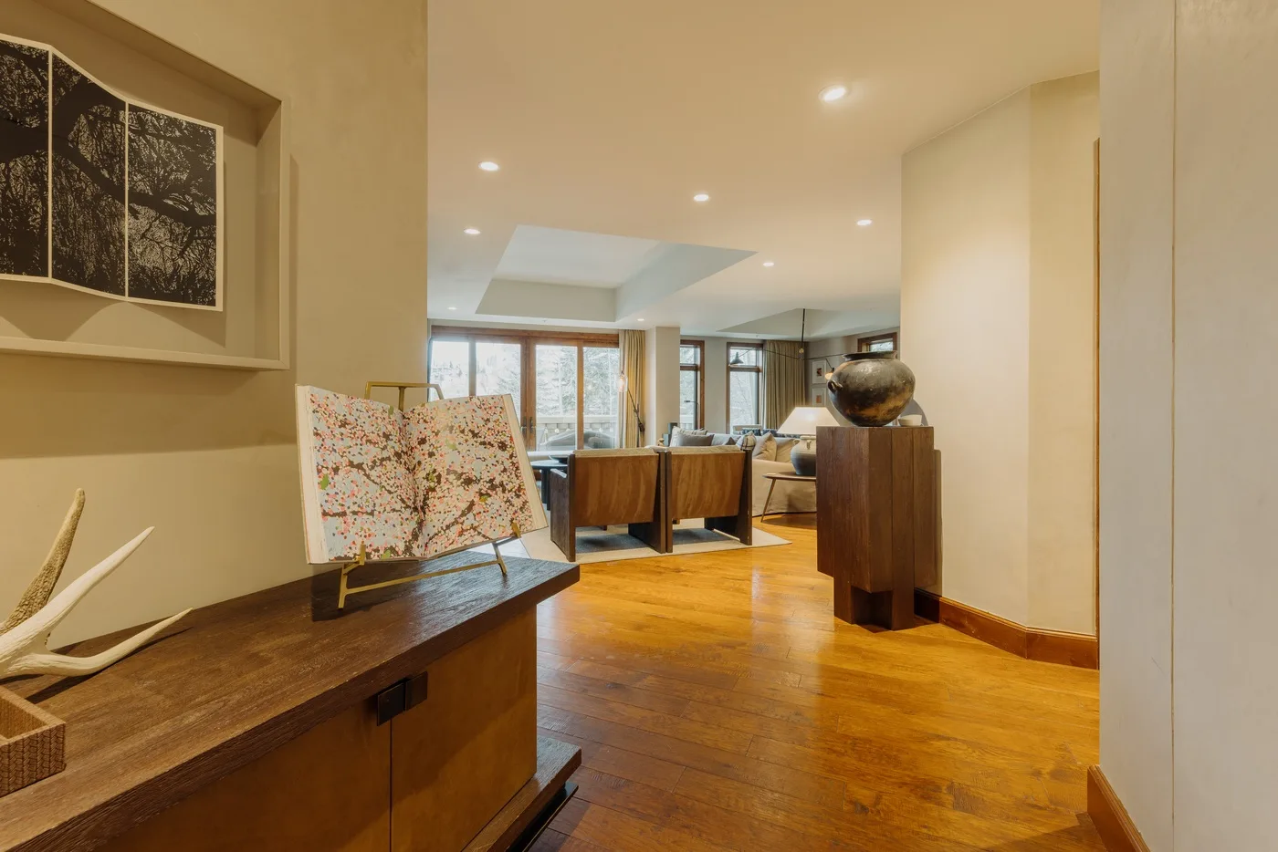 A warm-toned living room with wooden flooring and artwork on display.