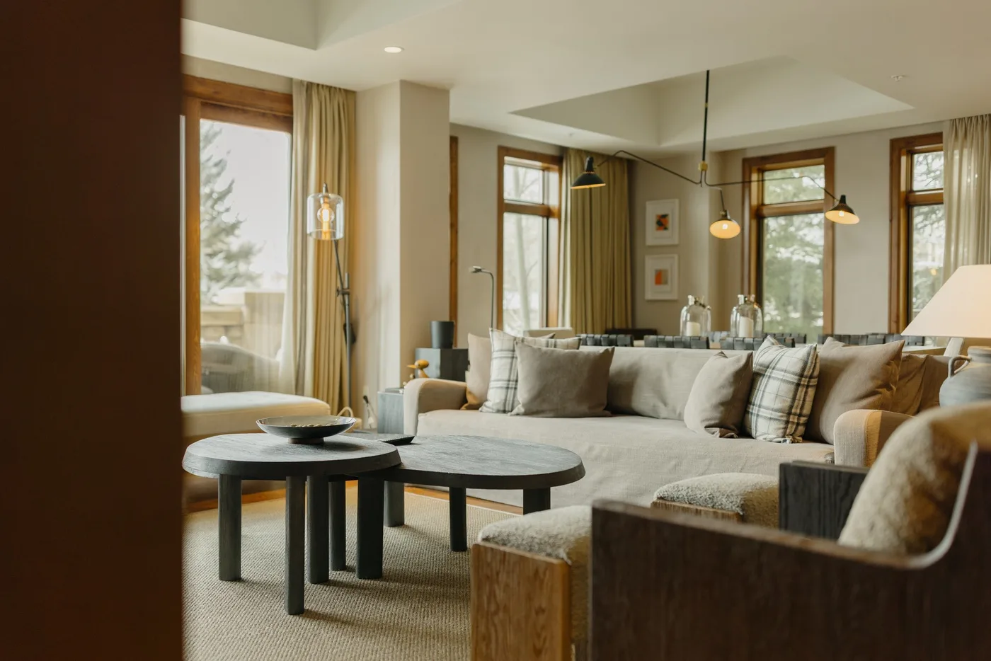 A bright living room with a large sectional seating area and windows.
