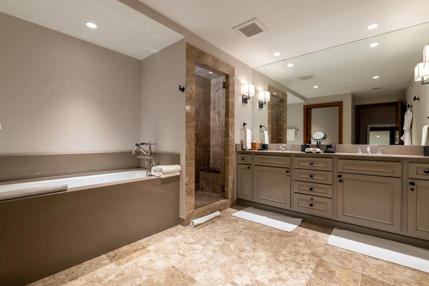 A spacious bathroom with a bathtub, shower, and long vanity.