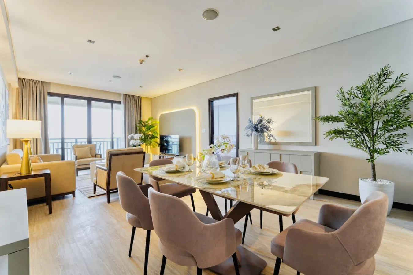 Comedor con una mesa preparada y asientos junto a grandes ventanales.