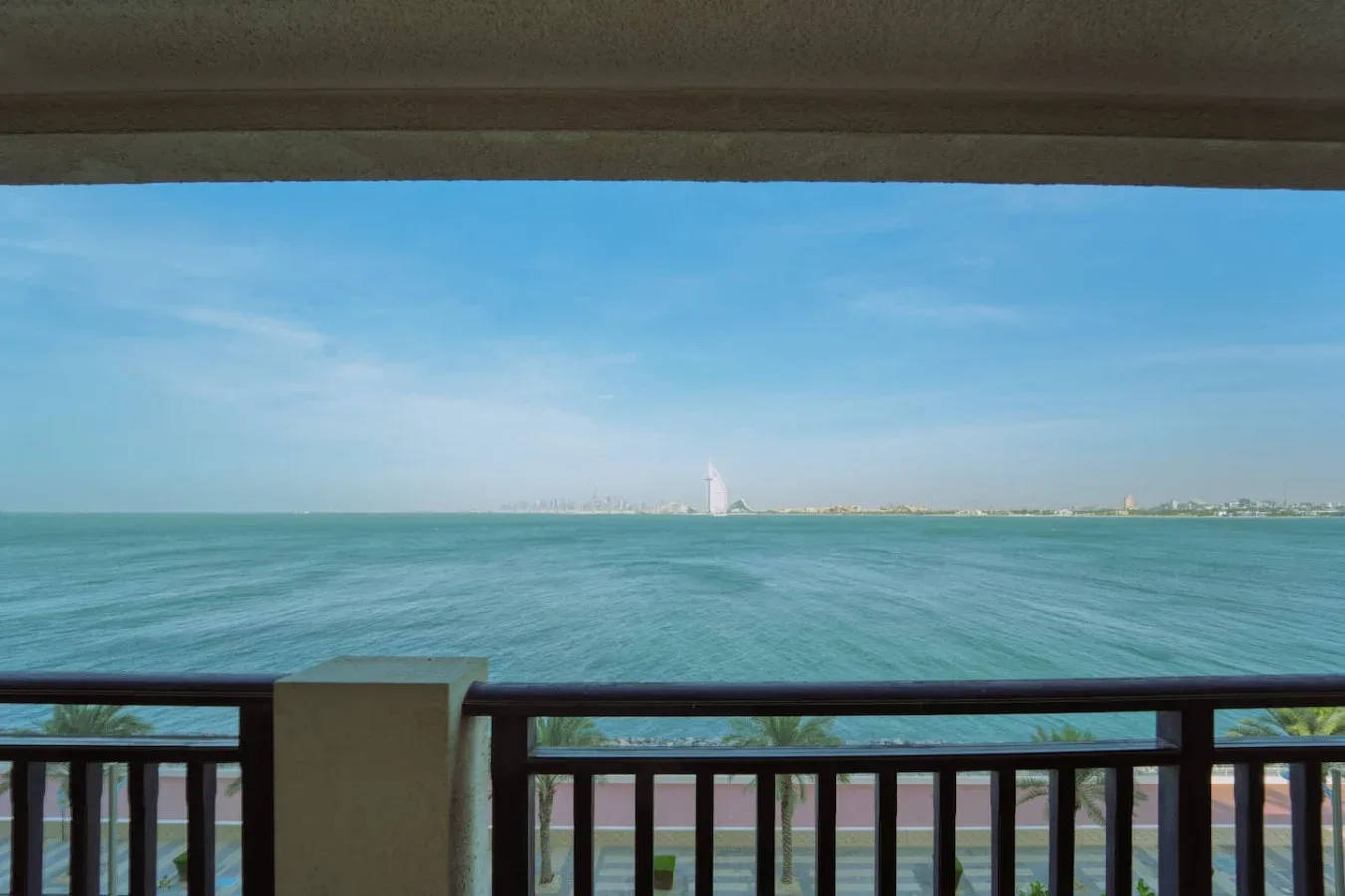 Un balcón da al mar, con una costa distante visible en el horizonte.
