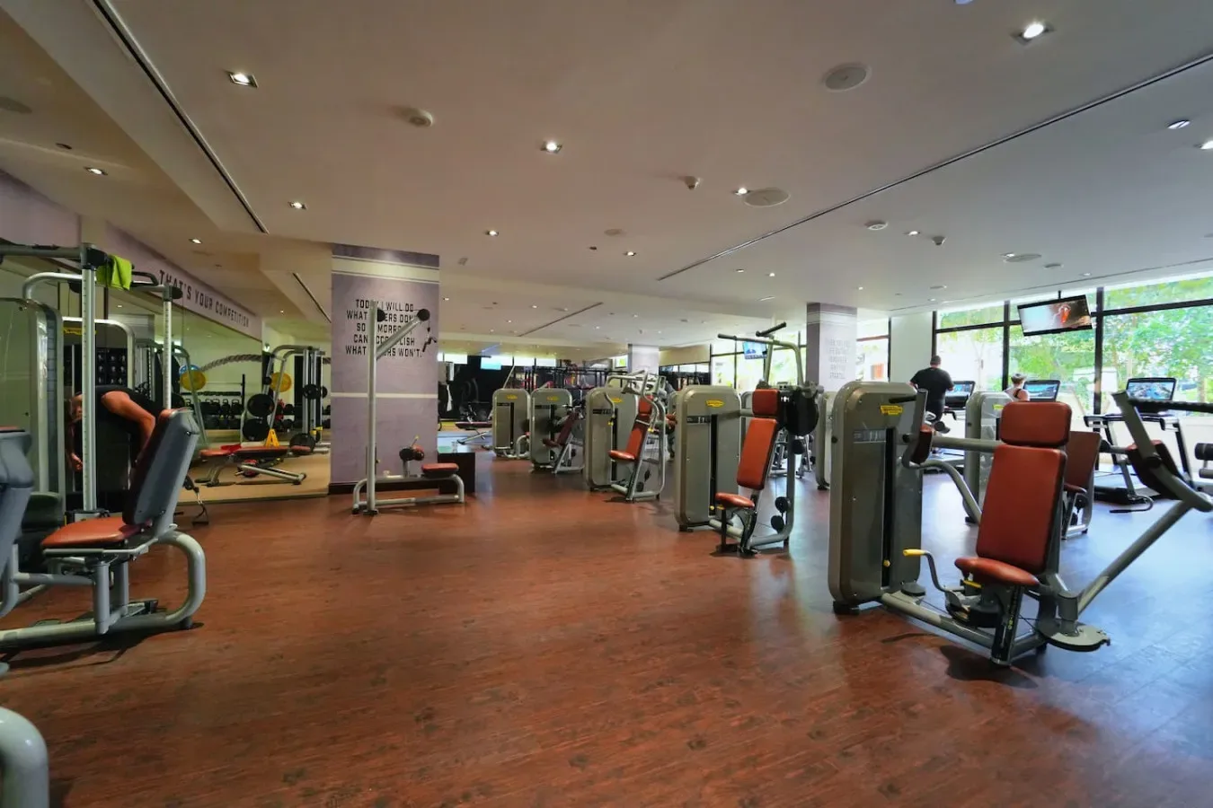 Un gimnasio con máquinas de ejercicio distribuidas por una sala amplia.