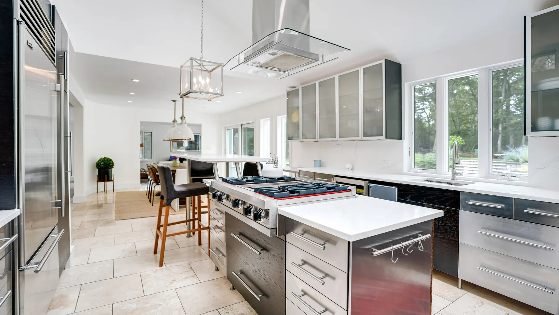 Una cocina moderna y luminosa con una isla central y grandes ventanas.