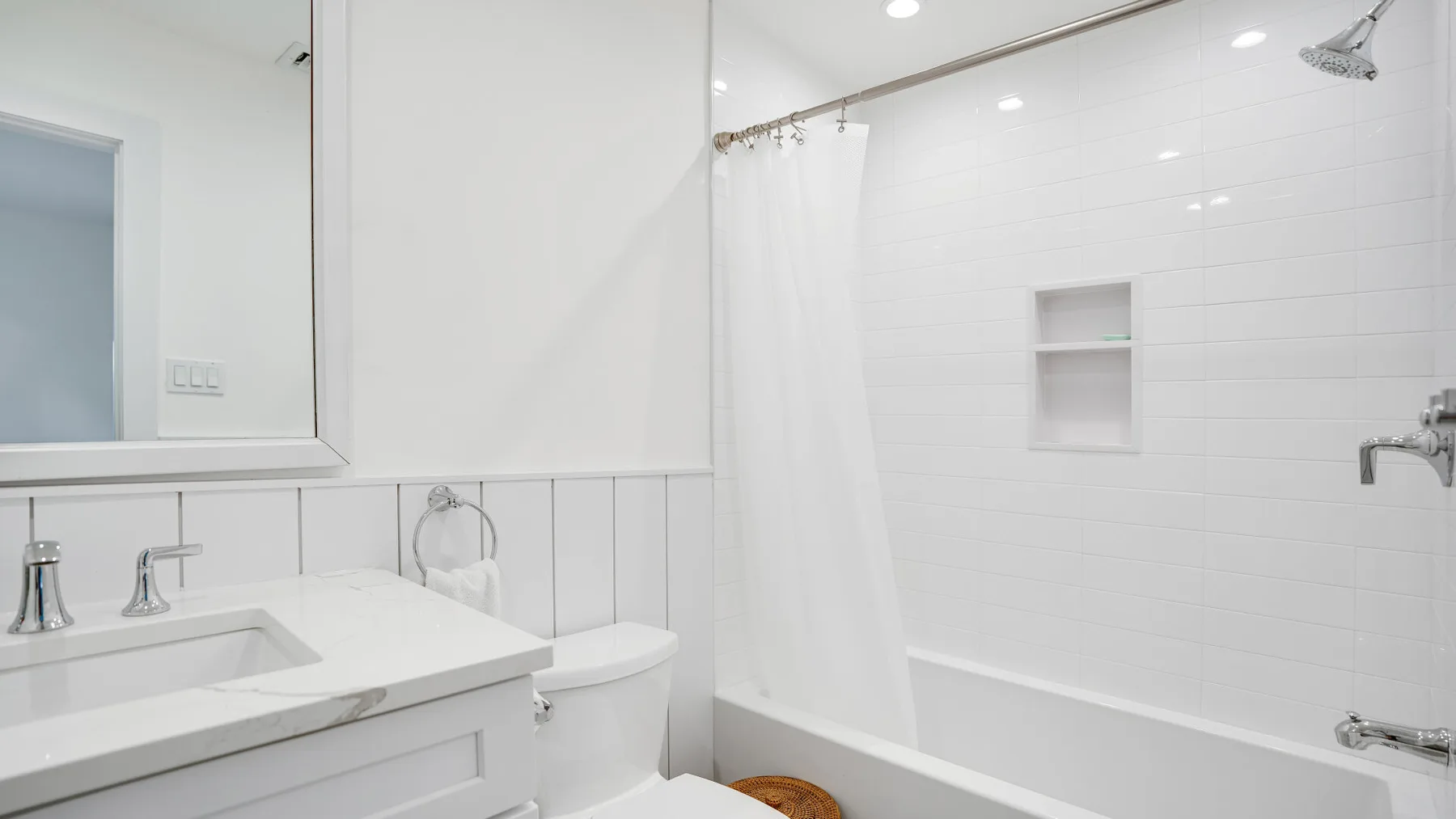 Un baño luminoso con bañera, cortina de ducha y lavabo.