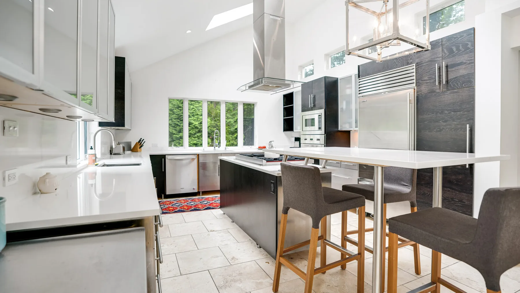 Una cocina moderna y luminosa con una isla central y asientos de barra.