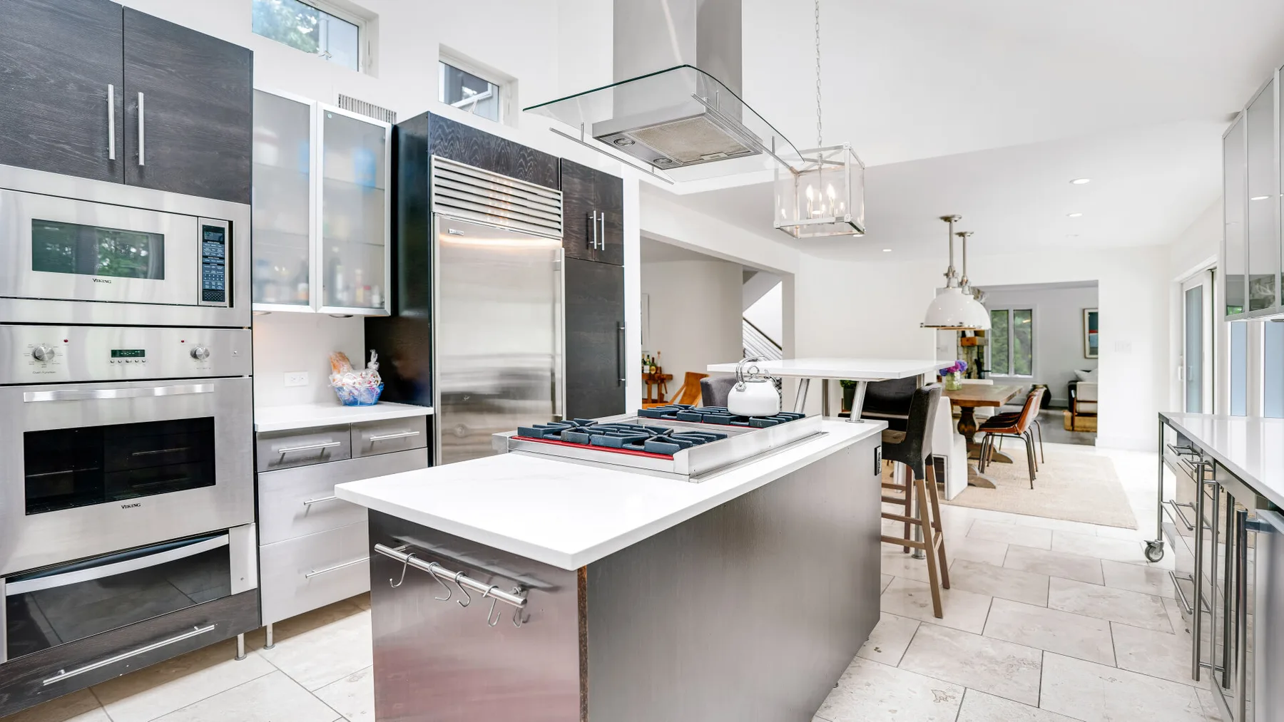 Una cocina moderna con una gran isla se abre a un comedor.