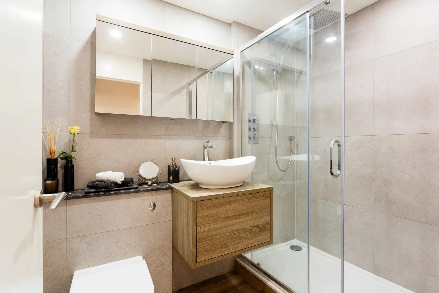 A modern bathroom with a vessel sink and glass shower.