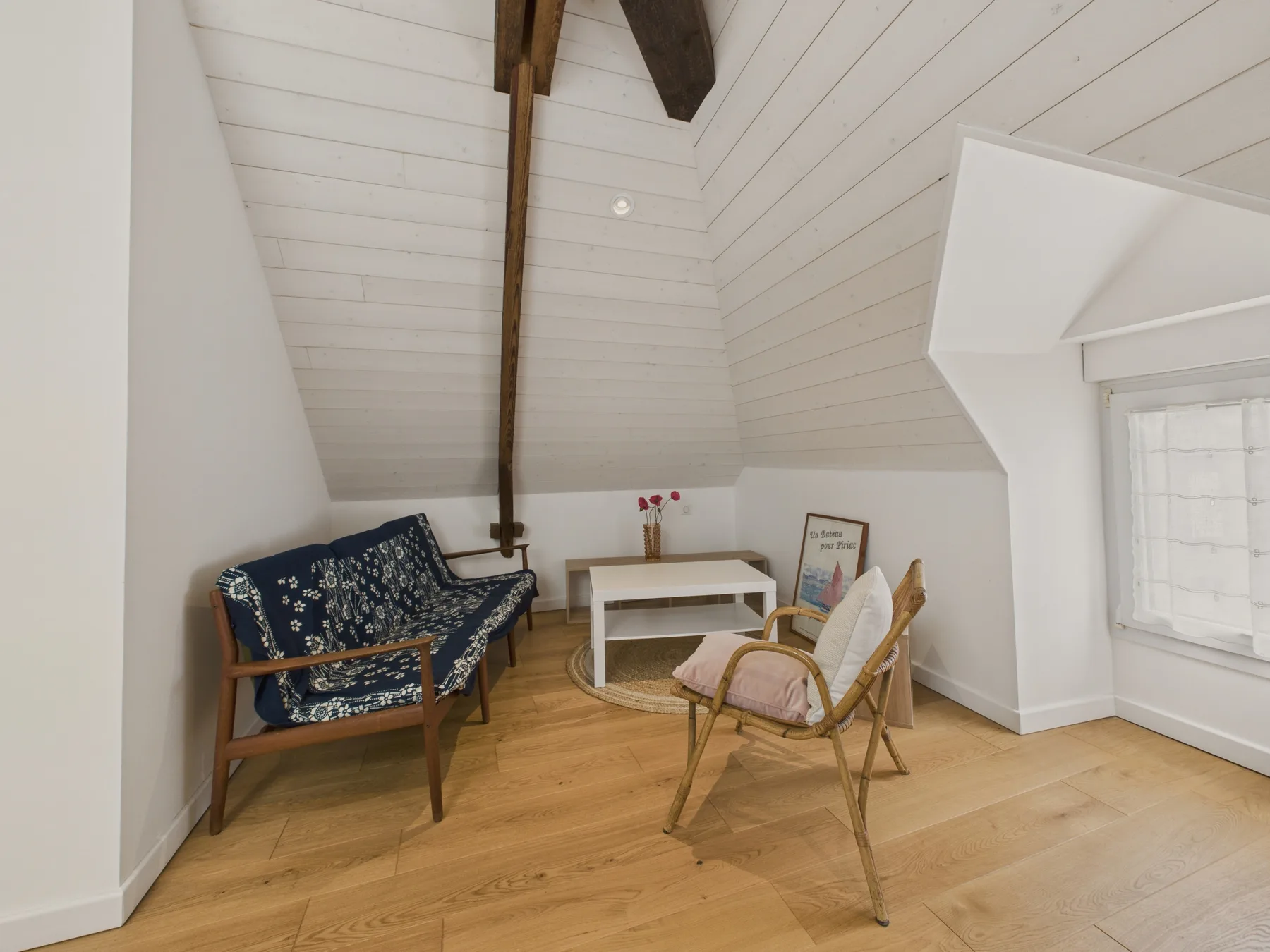 An attic sitting area with seating around a low table.