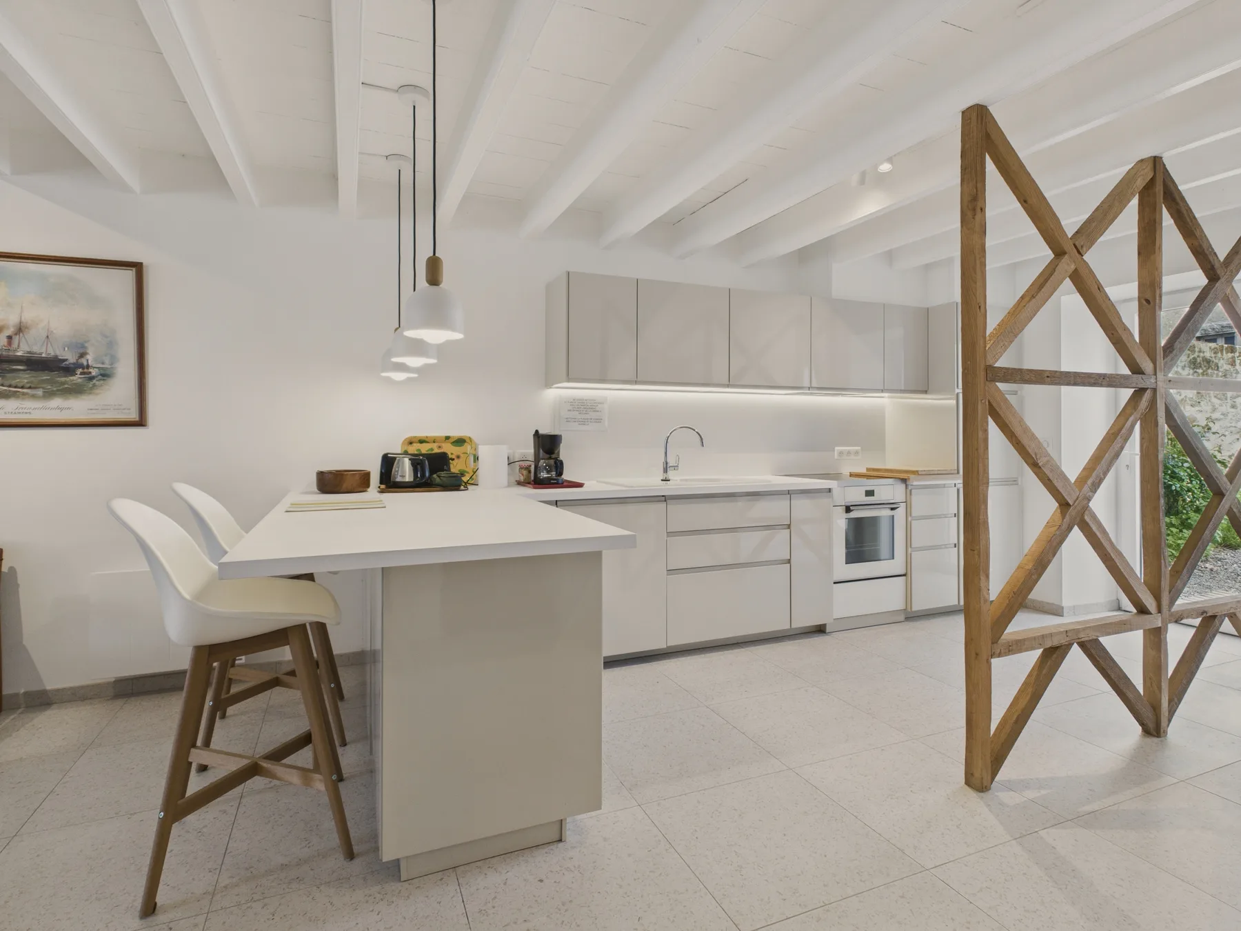A bright kitchen with a central island and white cabinetry.