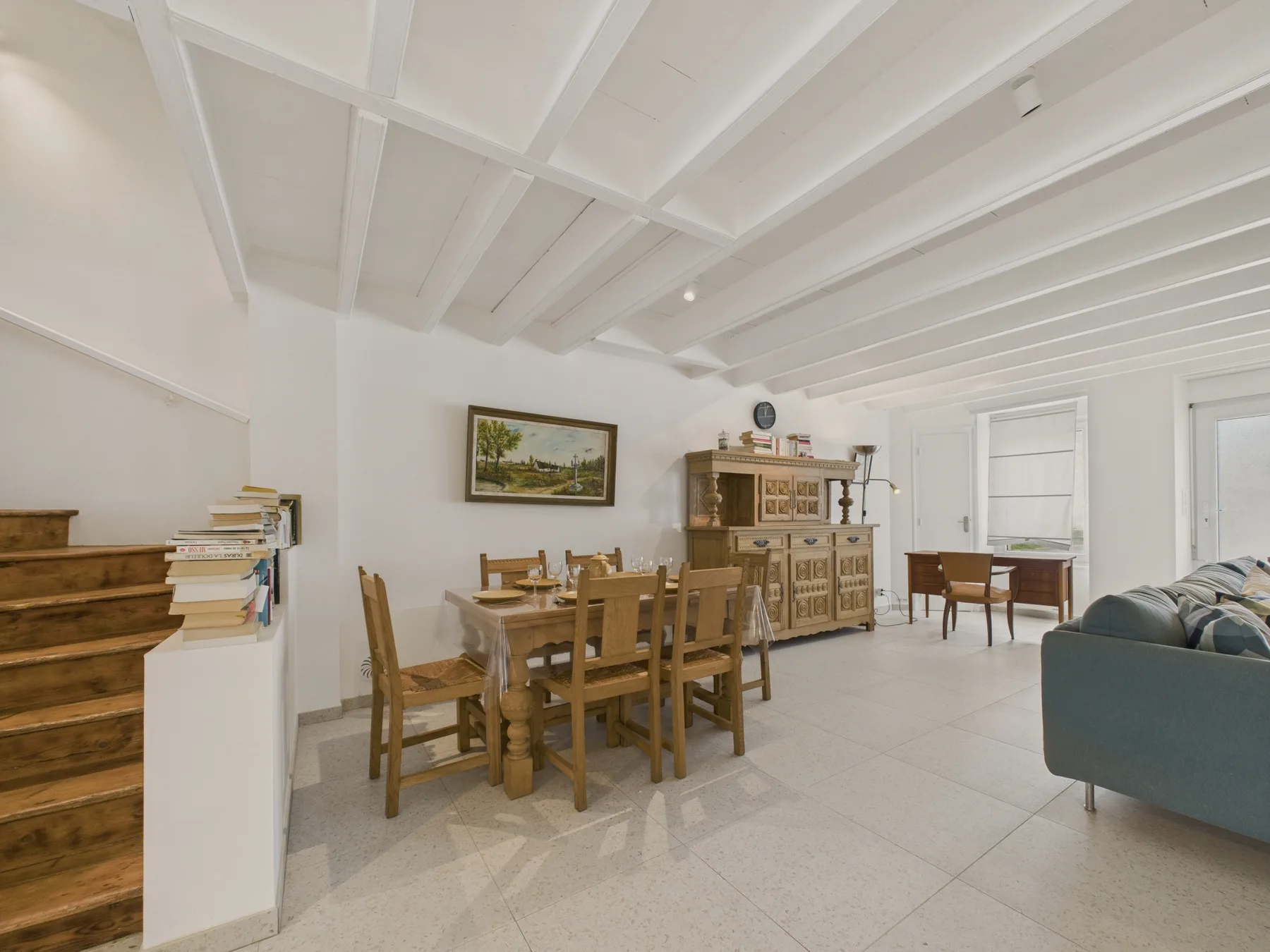 Dining and living area with a wooden dining table and seating.