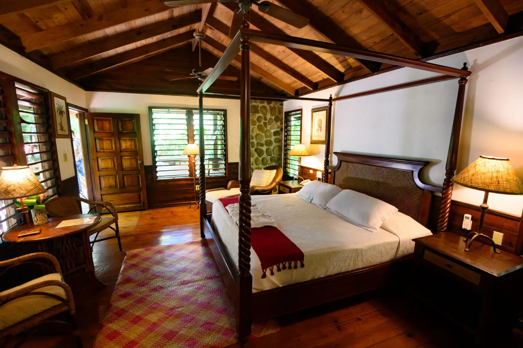 Un dormitorio con una cama de cuatro postes y techo de madera.