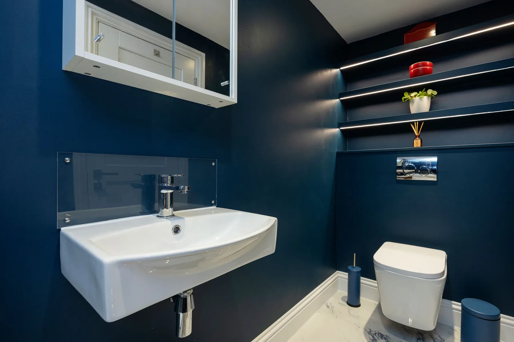 A compact bathroom with a wall-mounted sink and toilet.