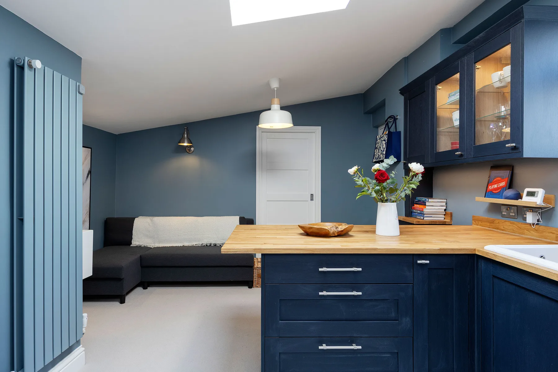 A blue-toned living area with a sectional sofa and a kitchen island in the foreground.