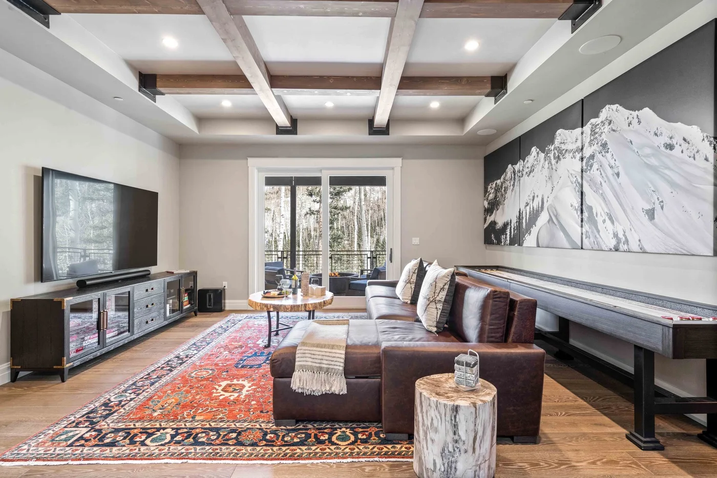 A living room with sectional seating, a patterned rug, and large windows.