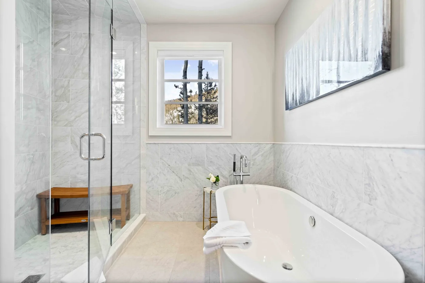 A bright bathroom with a bathtub and glass shower beside a window.