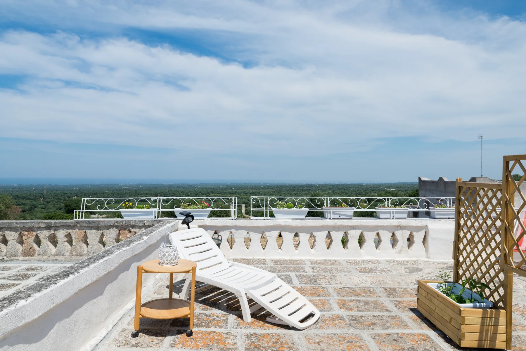 Terraza en la azotea con una tumbona blanca y una amplia vista del horizonte.