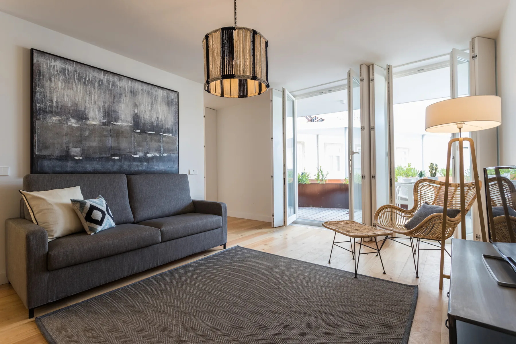 A living room with seating and large windows opening onto a terrace.