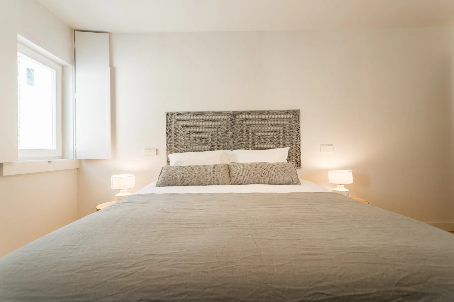 Dormitorio con una cama bajo un cabecero estampado.
