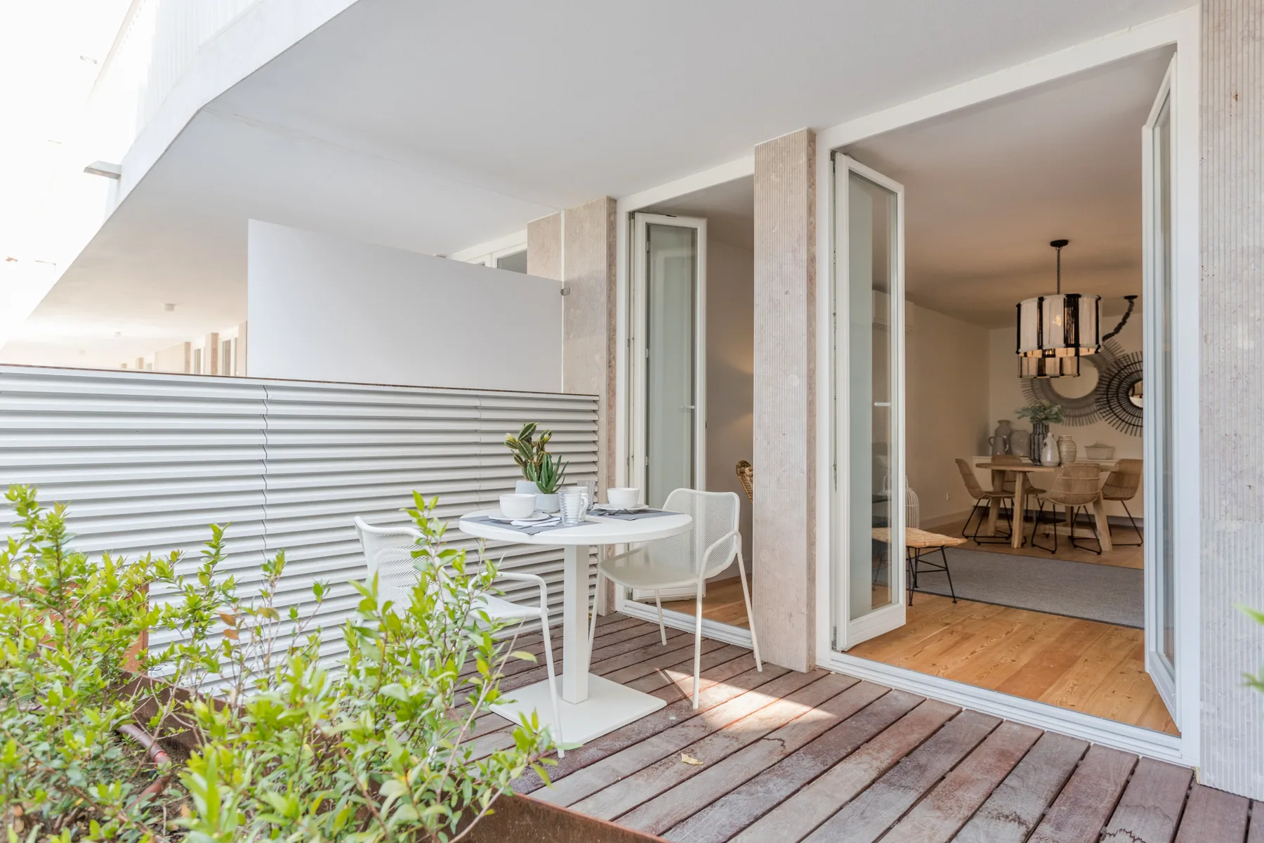 A furnished terrace with a dining table opens onto an indoor dining area.