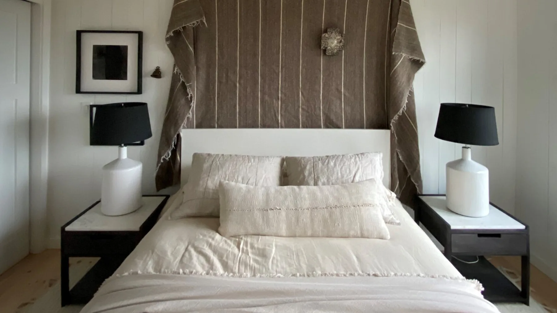A bedroom with a neatly made bed and matching bedside tables.