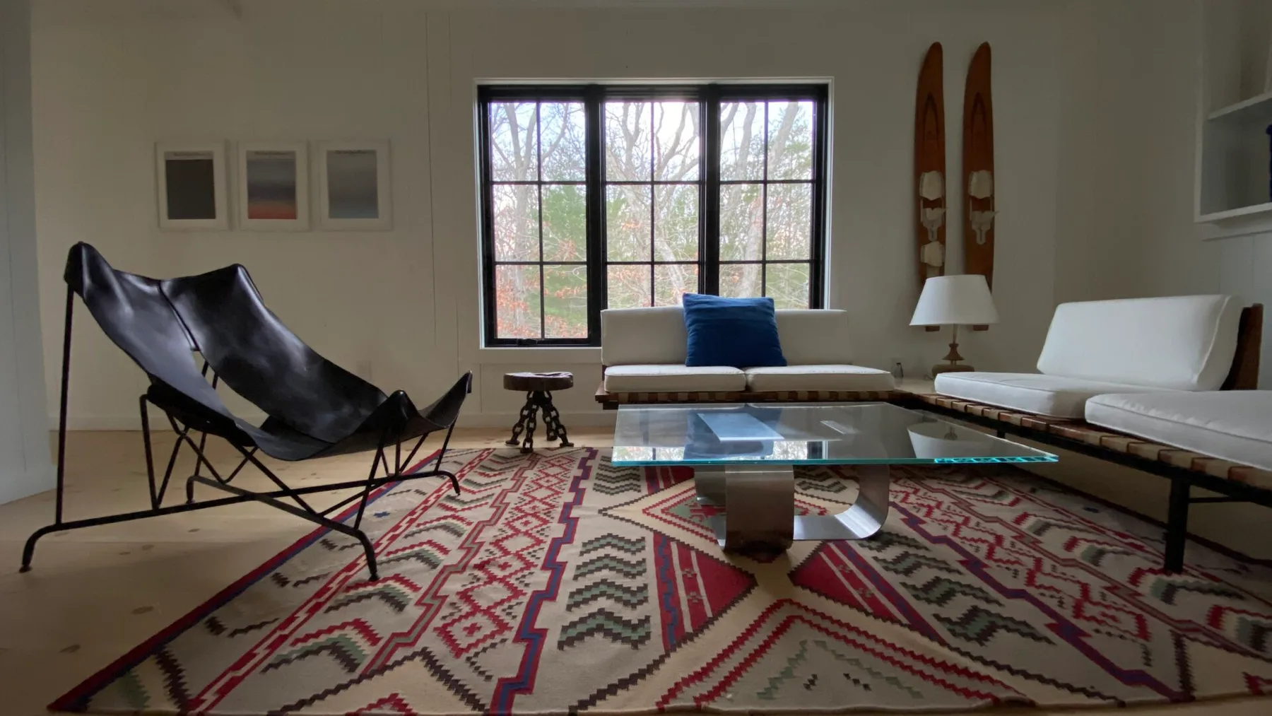 A living room with a low table on a patterned rug beside a large window.