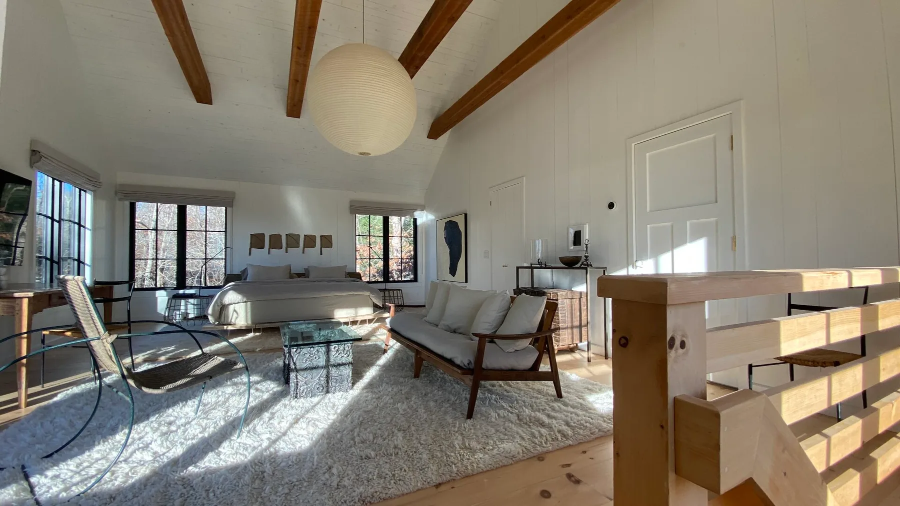 A bright living room with seating around a low table and large windows.