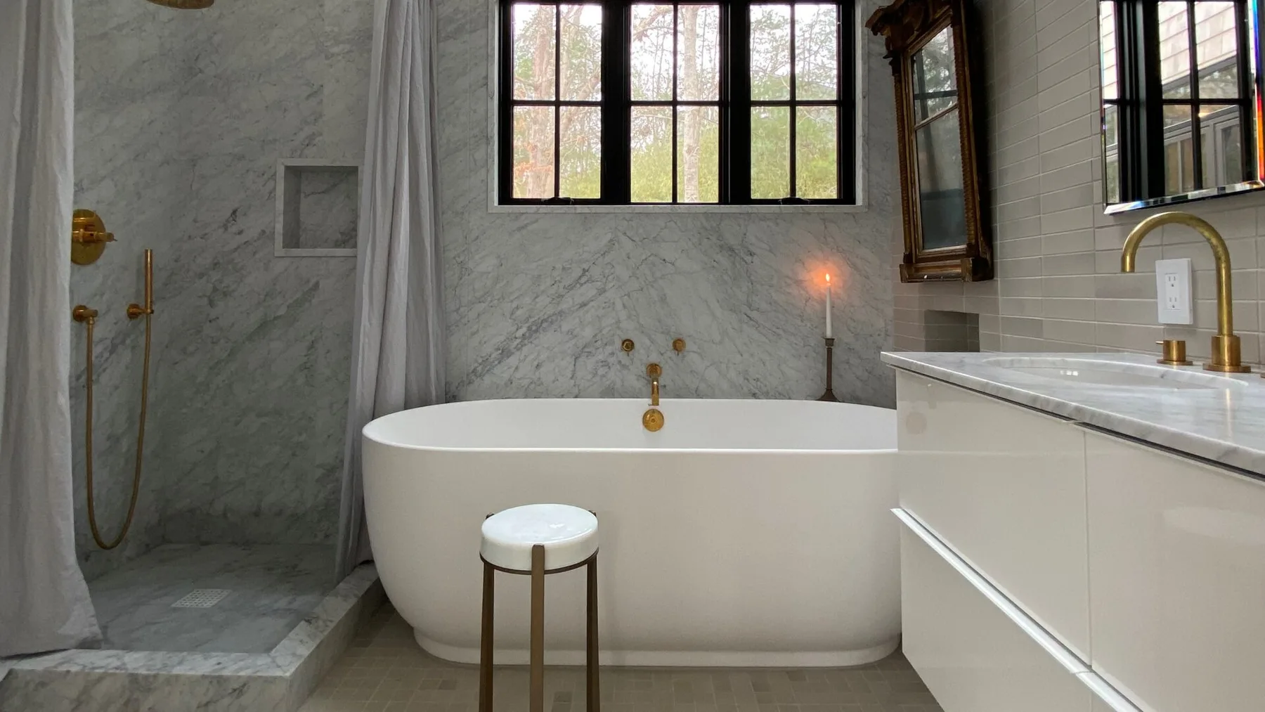 A bathroom with a freestanding bathtub beside a walk-in shower.