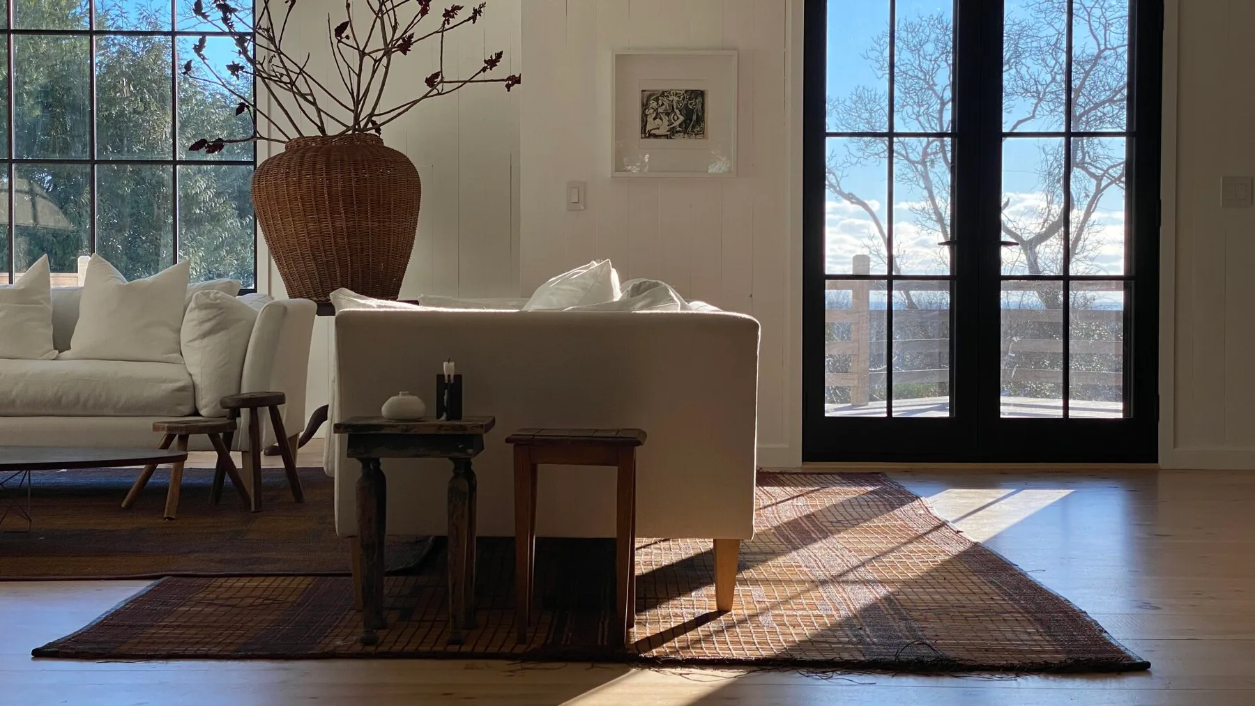 Una sala luminosa con asientos junto a ventanas altas y una alfombra tejida.