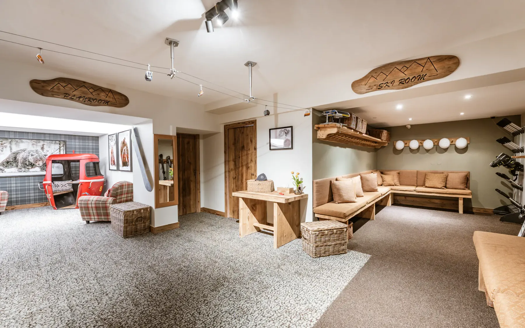 Spacious ski-themed room with cozy seating, wood accents, a red ski lift chair, and decorative wall elements.