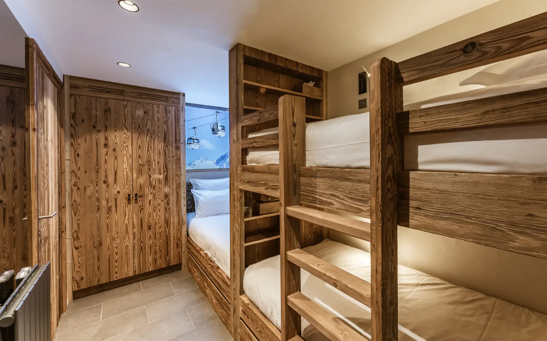 Cozy room with wooden bunk beds and a wardrobe, featuring warm lighting and a rustic wooden interior.