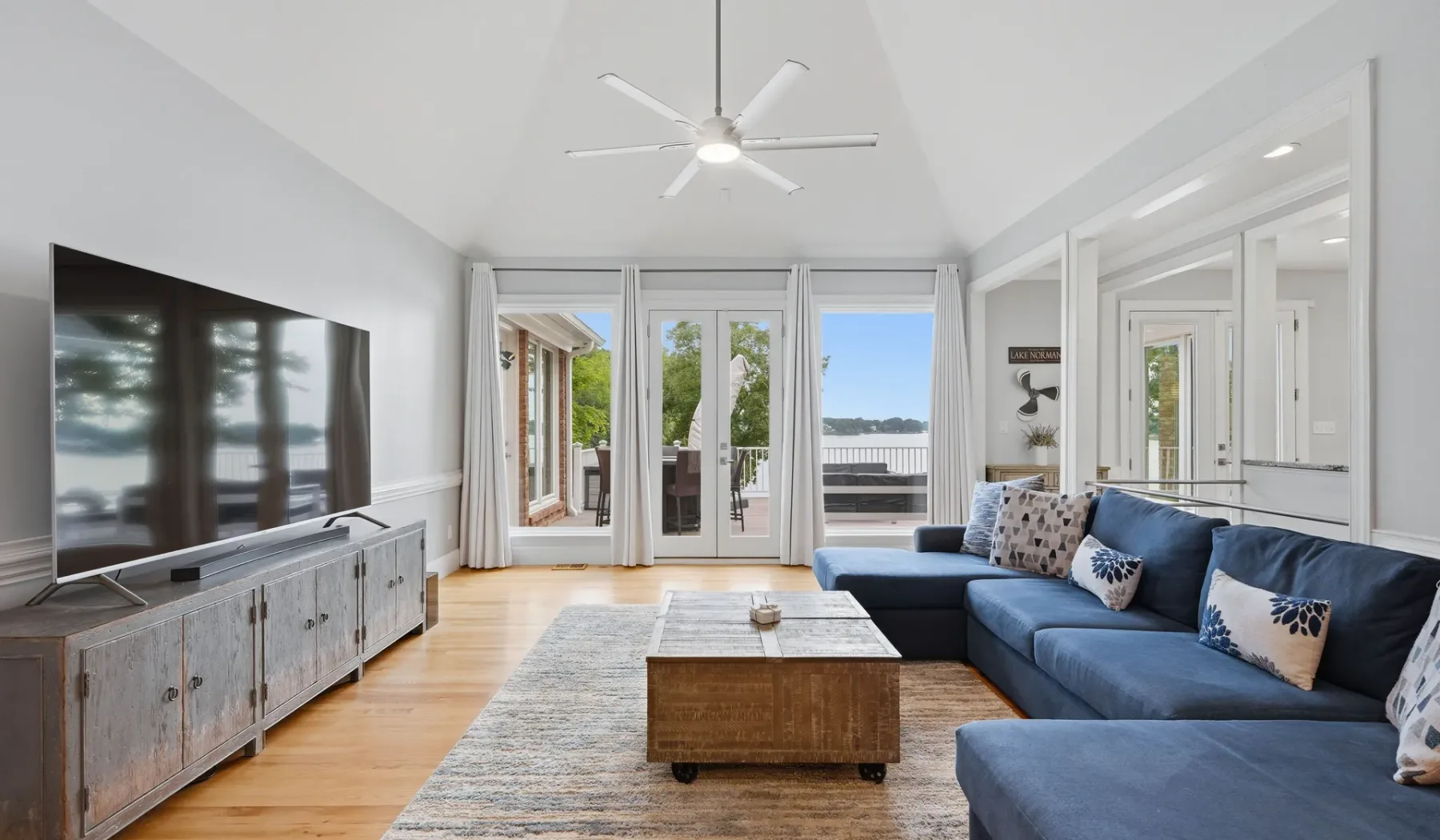 A bright living room with blue seating and glass doors opening onto a patio.