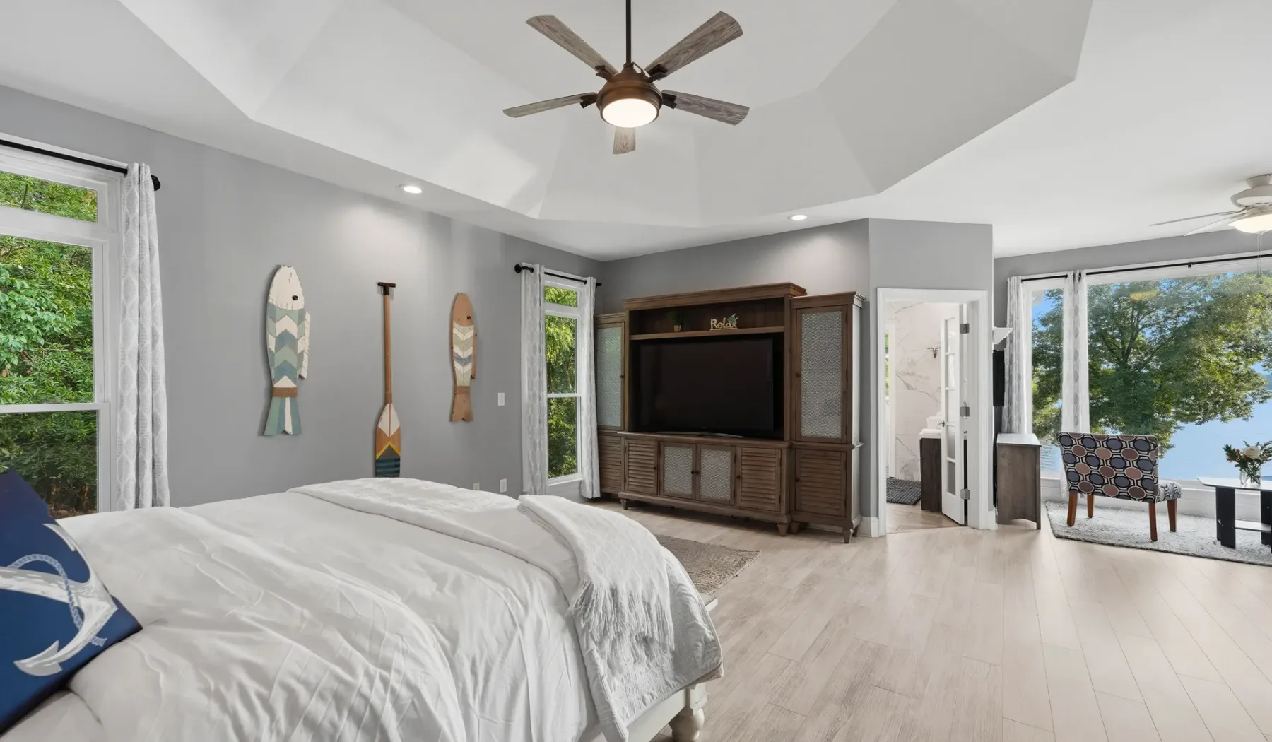 A bright bedroom with a large bed and a television cabinet.