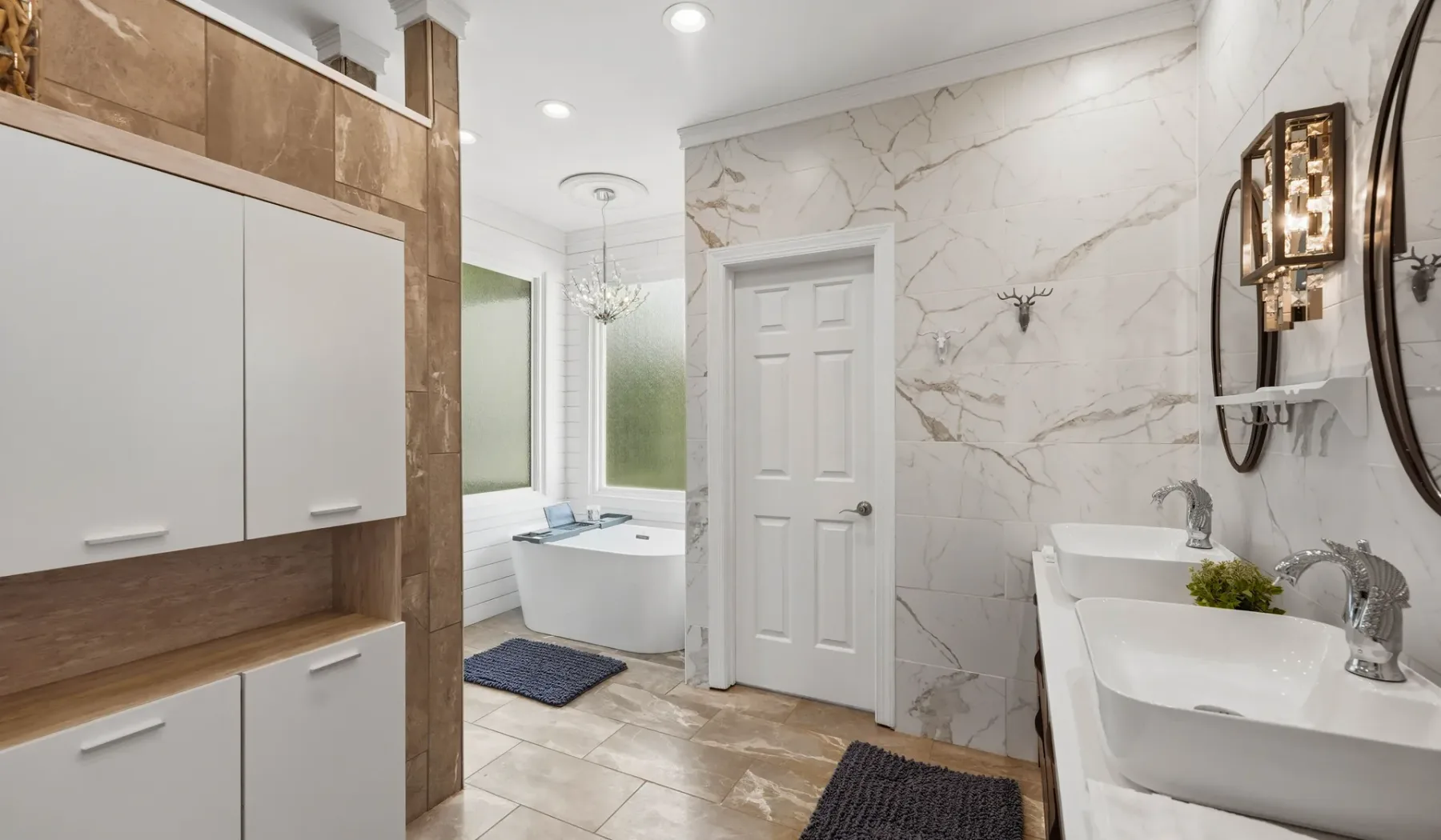 A bright bathroom with a bathtub, vanity sinks, and marble-patterned walls.