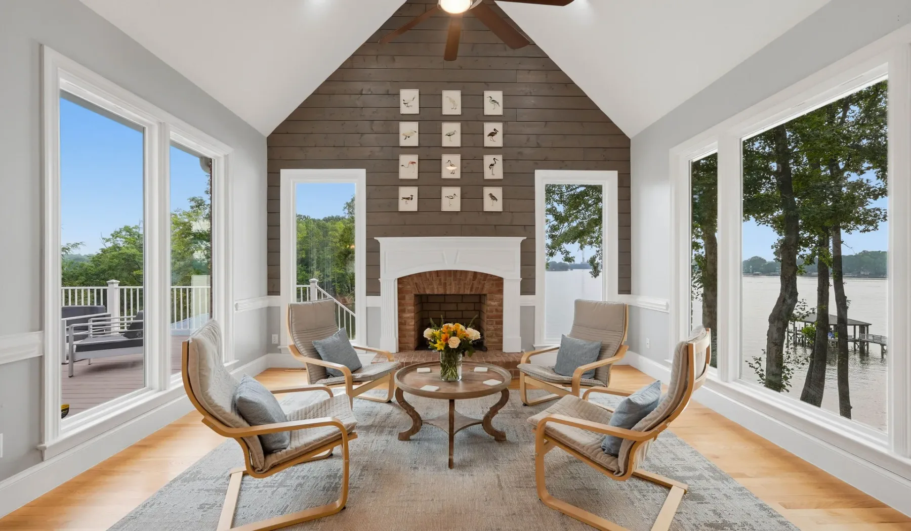 A bright sitting area with lounge seating around a coffee table beside large windows.