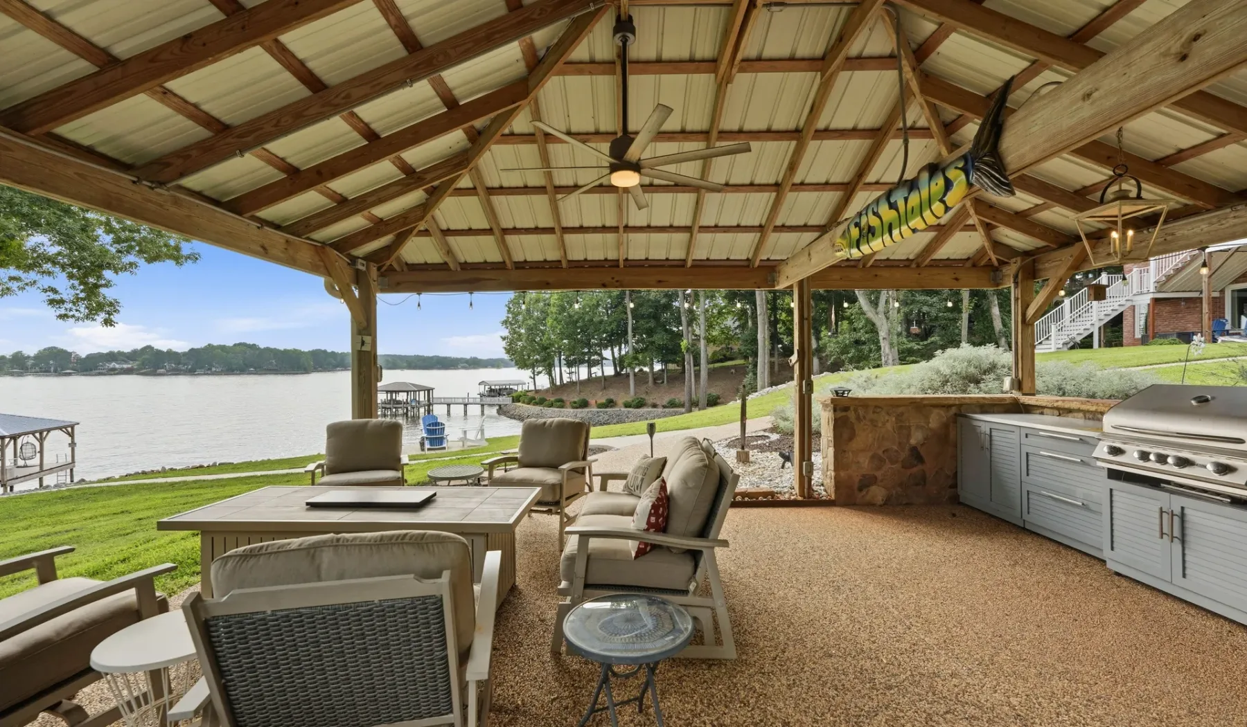A covered outdoor seating area overlooks a body of water.