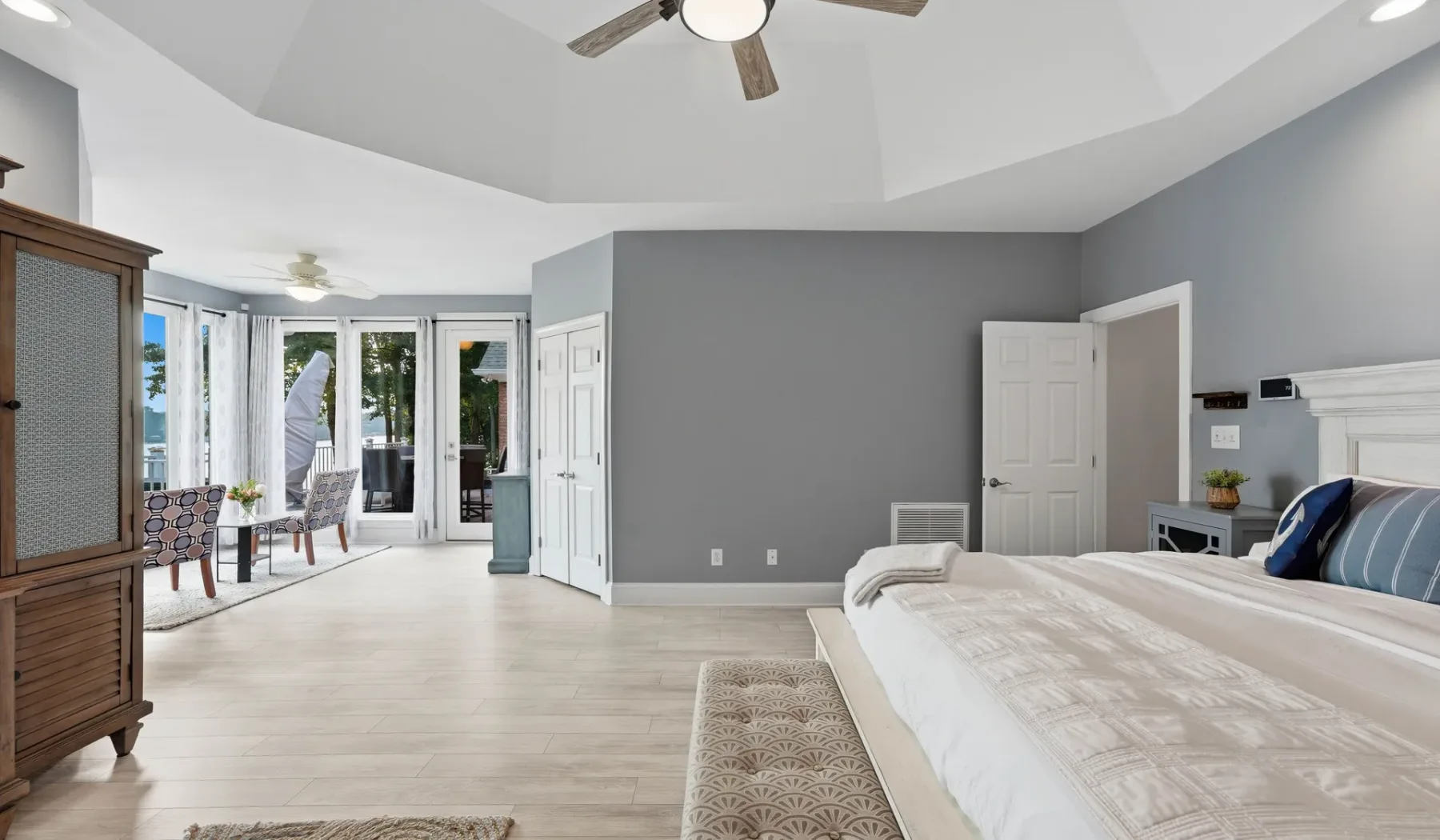 A bright bedroom with a large bed and glass doors opening onto a patio.
