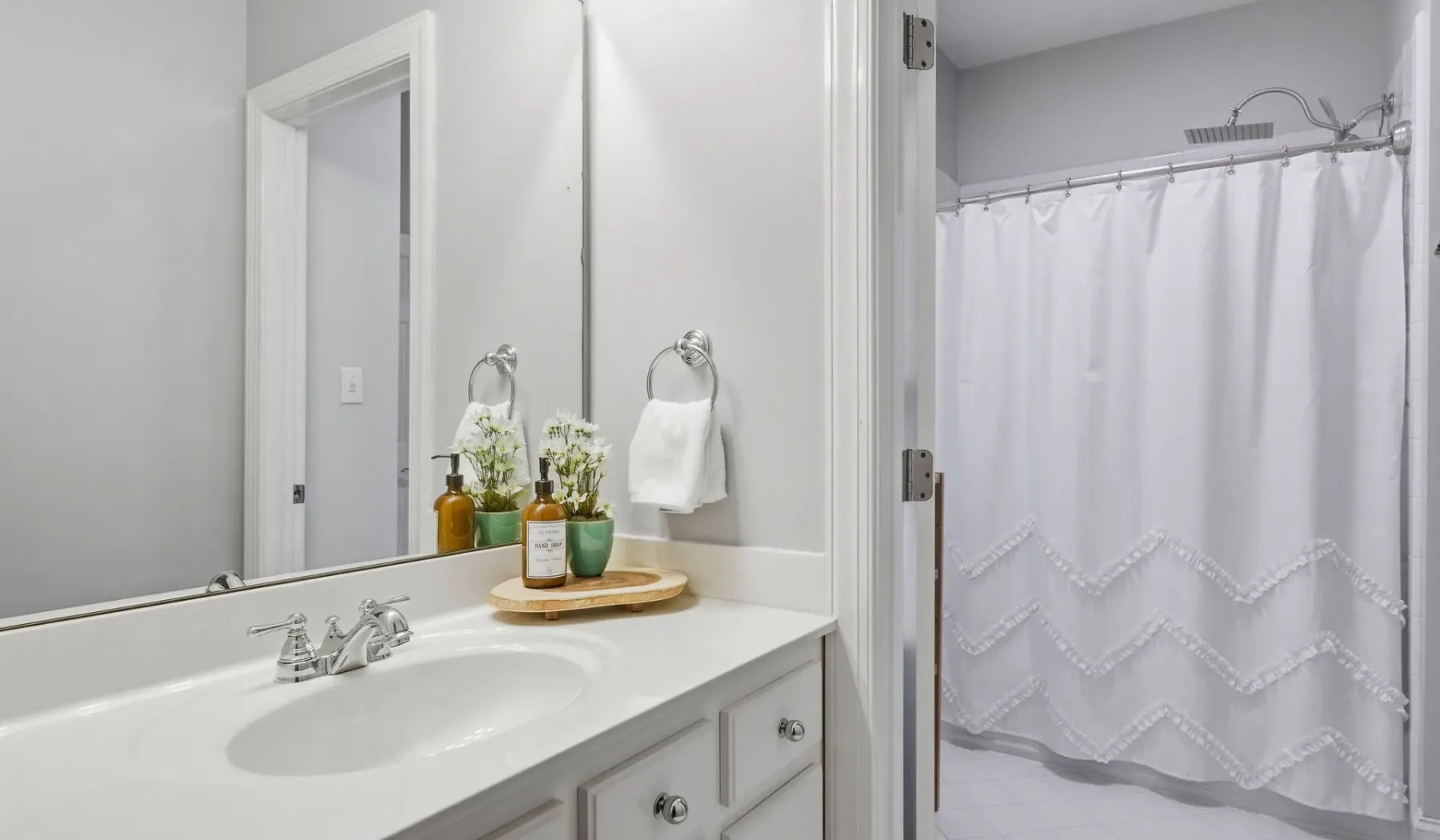 A bathroom vanity with a sink and a shower curtain.