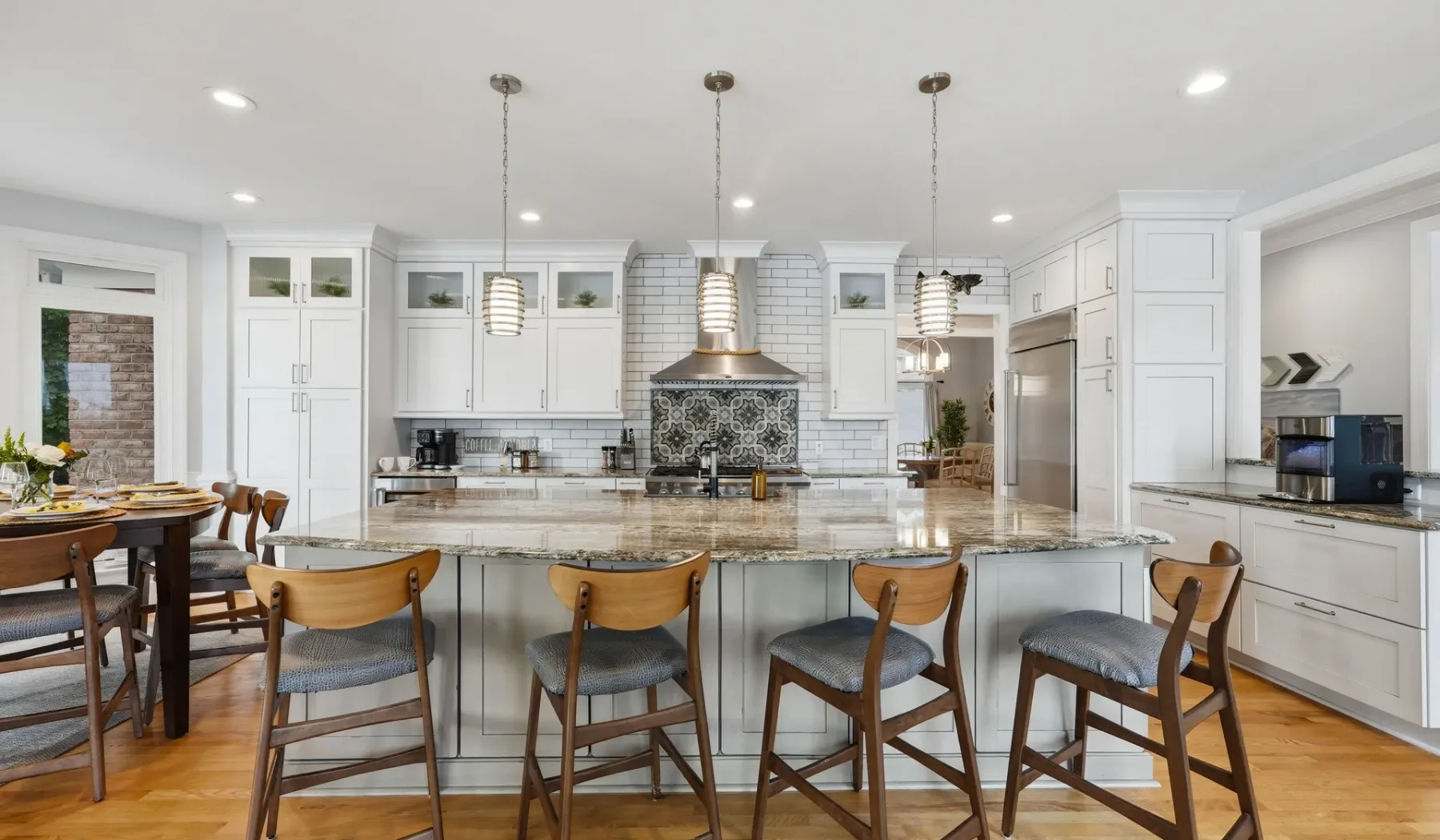 A bright kitchen with a large island and a dining table.