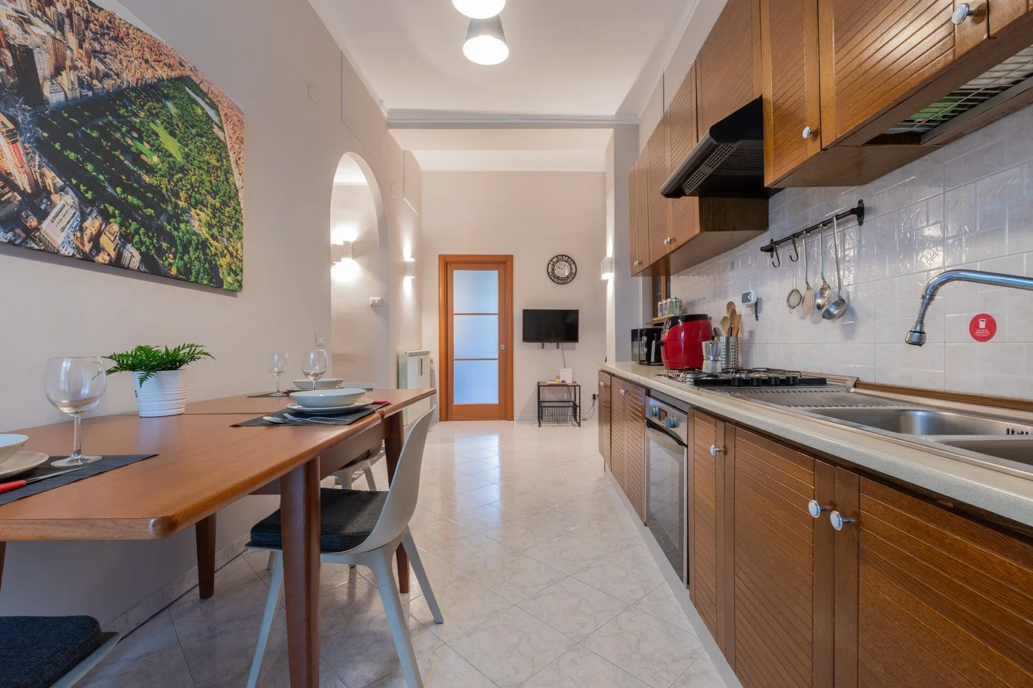 A long kitchen and dining area with wooden cabinets, a counter, and a dining table.