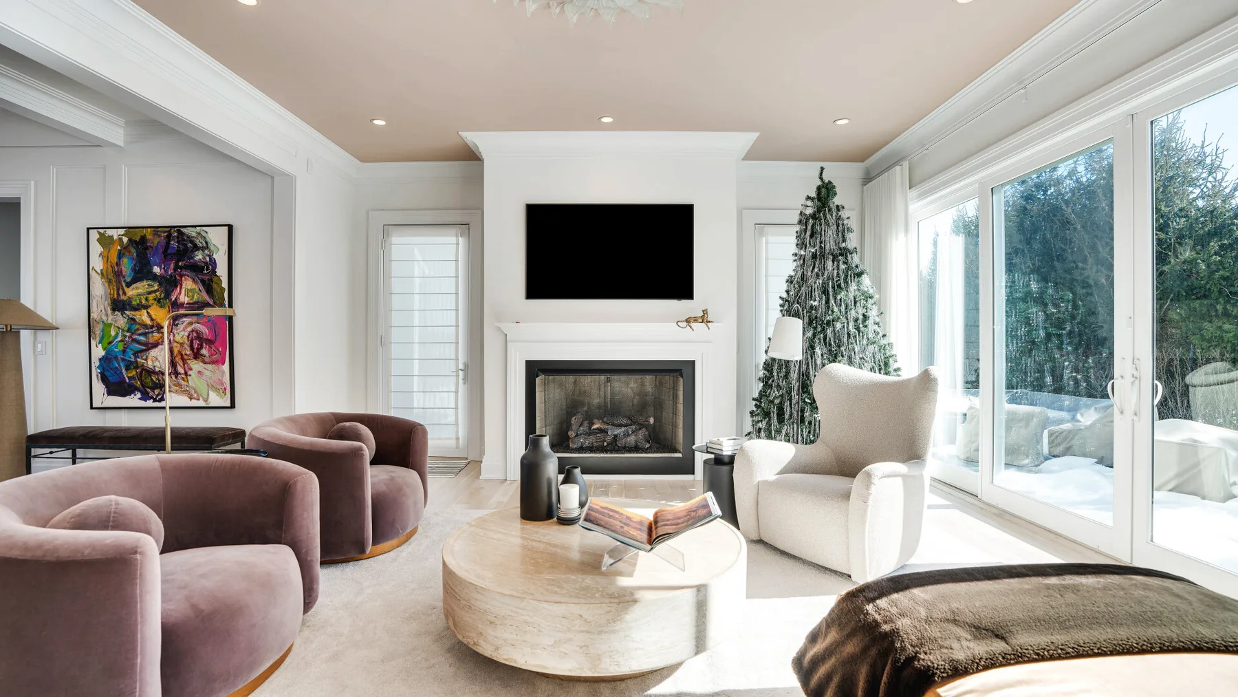 Una sala luminosa con chimenea, asientos y ventanas grandes.