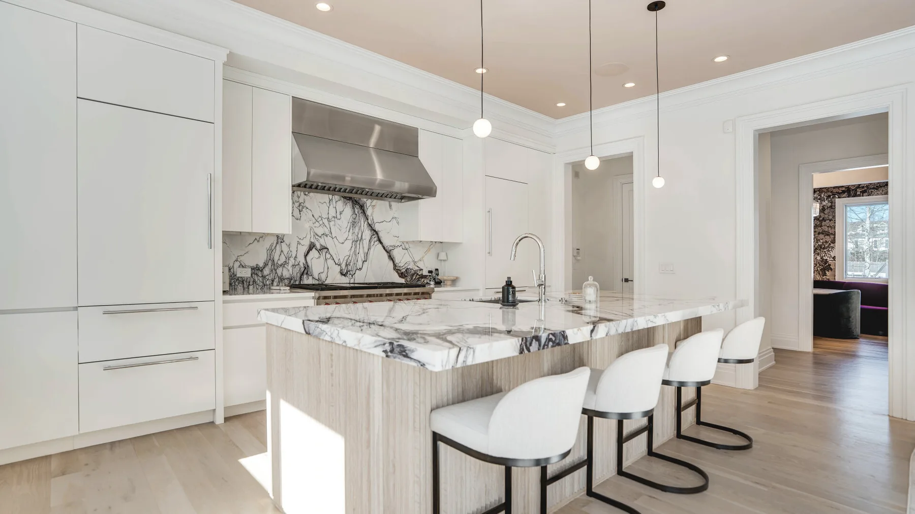 Una cocina luminosa con una isla grande y asientos.