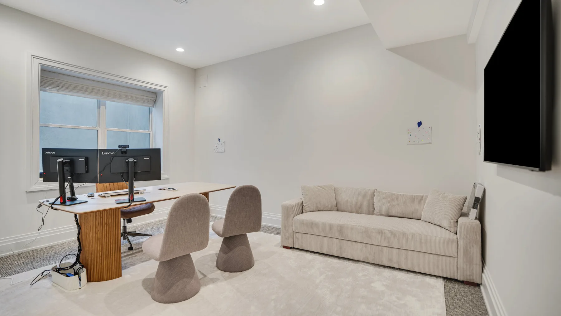 Una habitación luminosa con escritorio y asientos junto a una ventana.