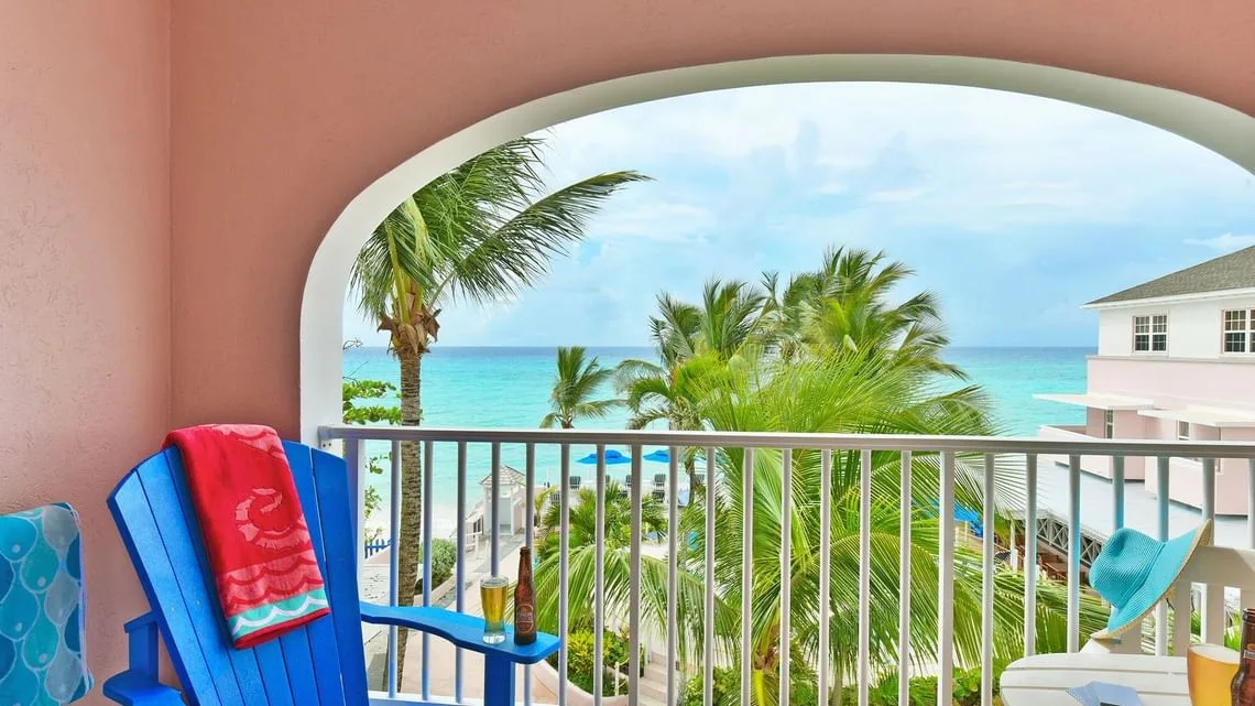 Balcón del estudio deluxe con vistas al océano, una silla azul y vistas al océano