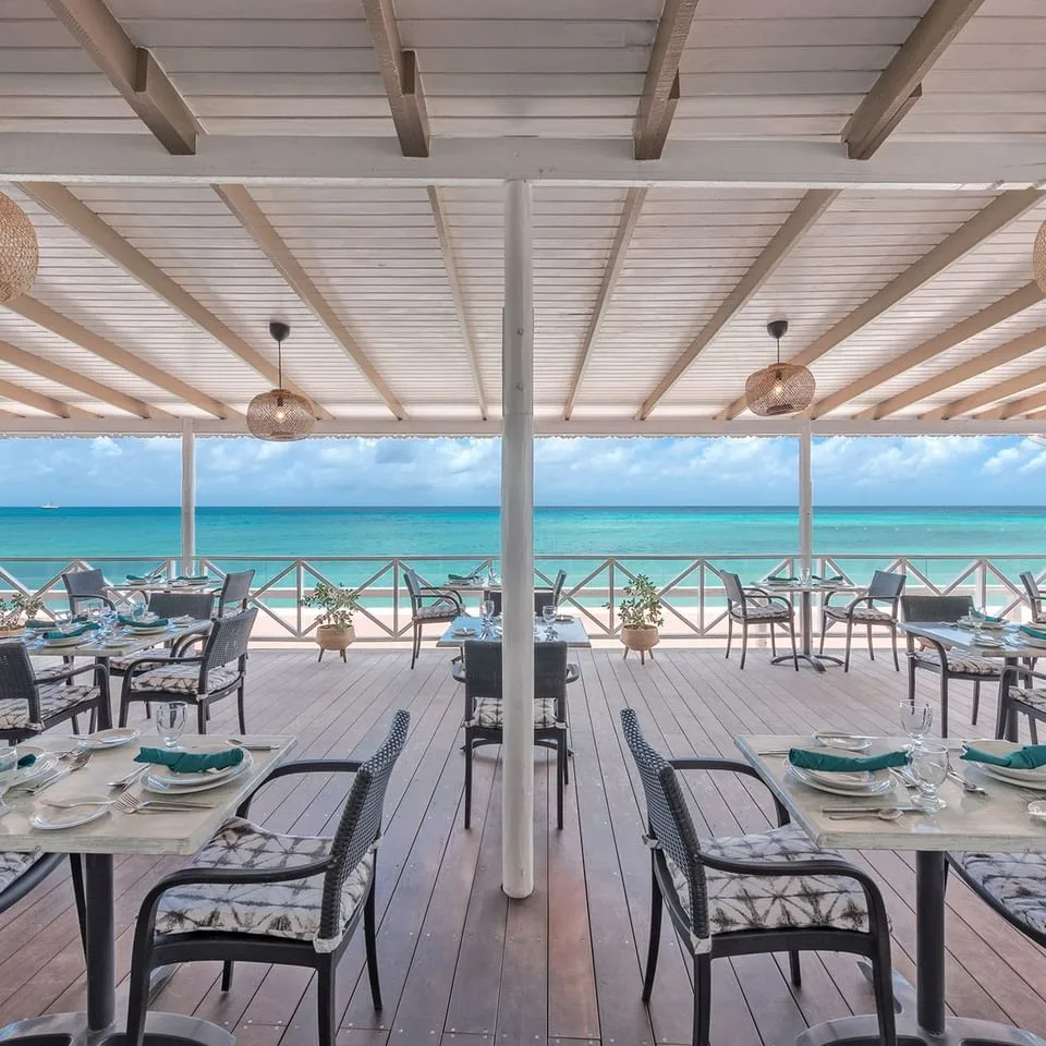 Zona de mesas al aire libre del restaurante con vistas al océano