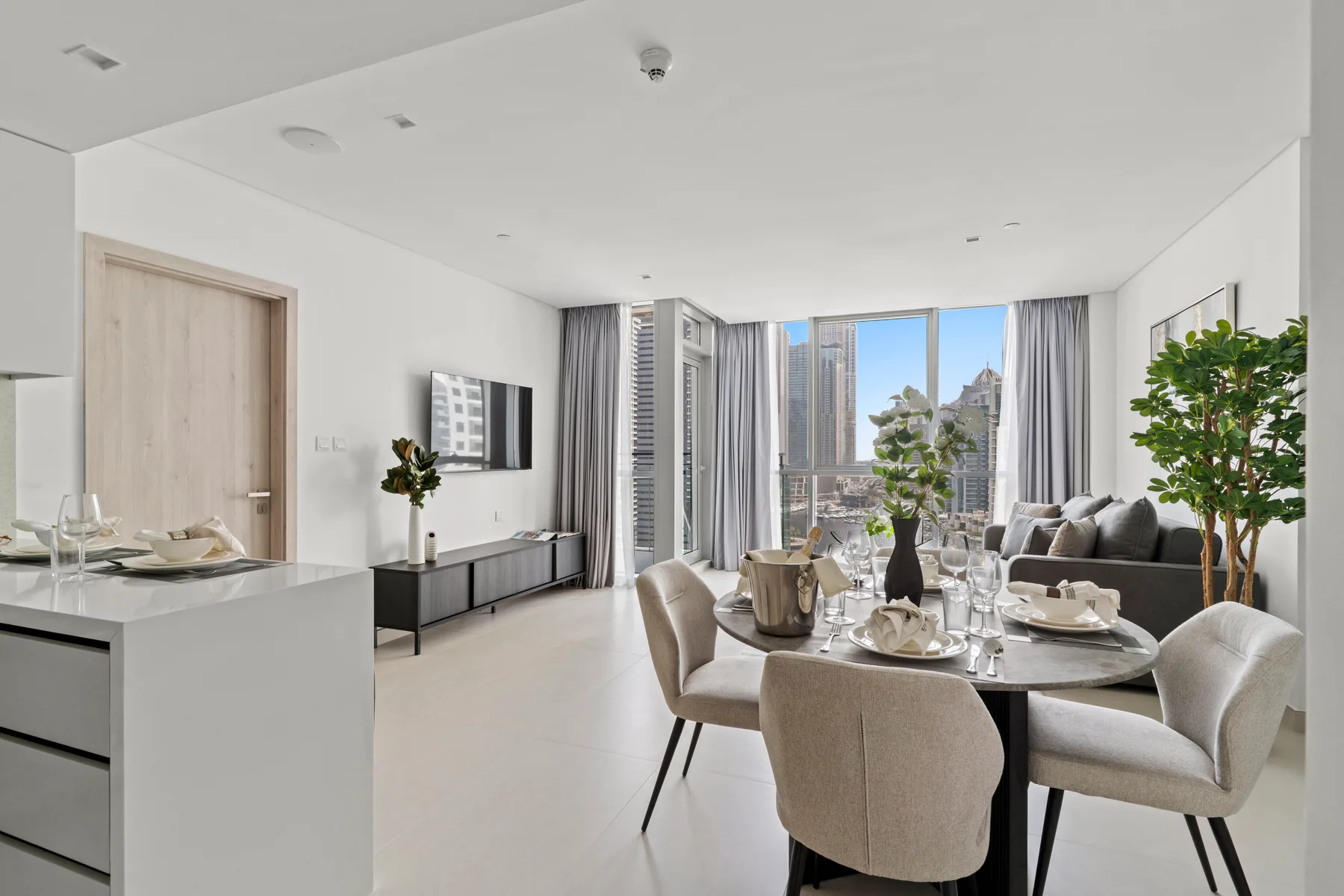 A bright open-plan dining and living area with floor-to-ceiling windows.