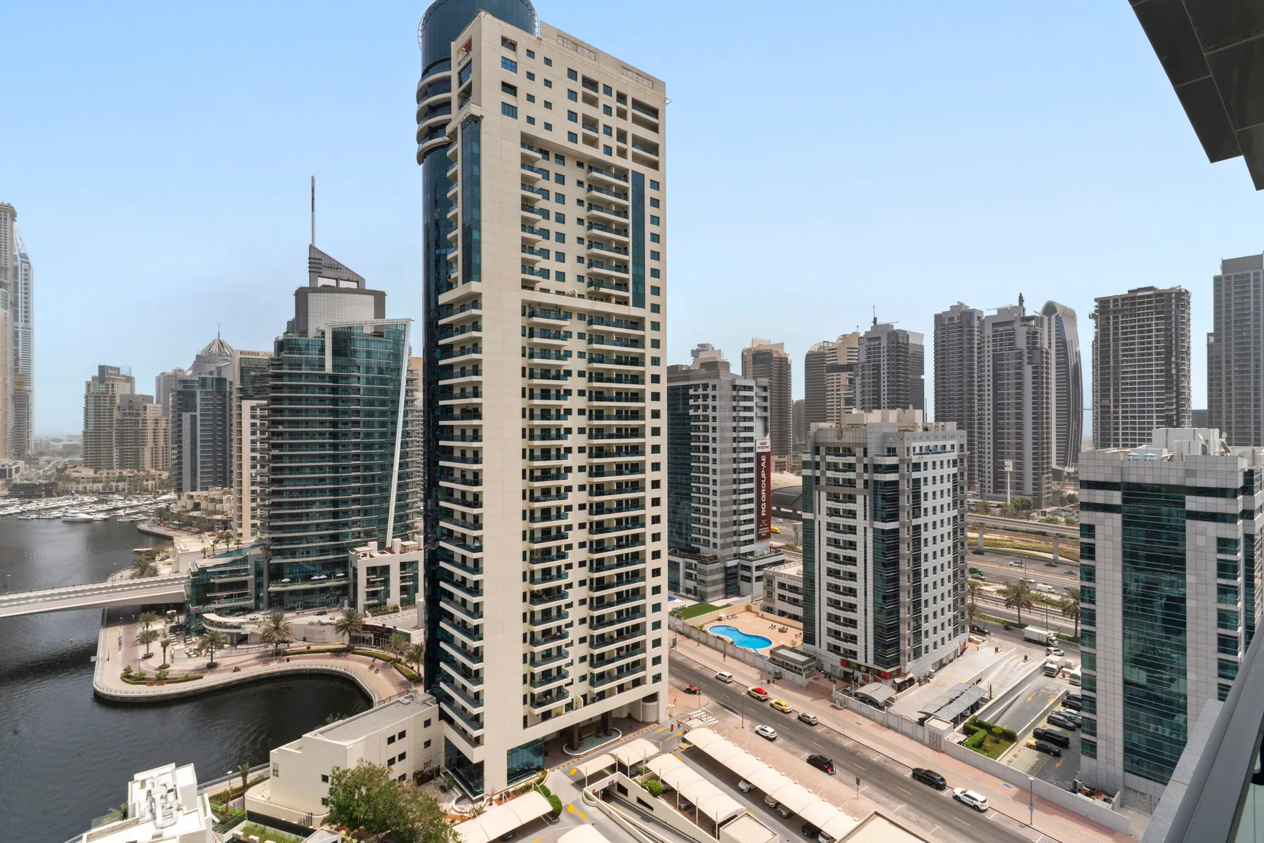 A city skyline of high-rise buildings surrounds a waterfront canal and roads.